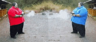 Two Fat Men Holding Guns In A Shooting Range GIF