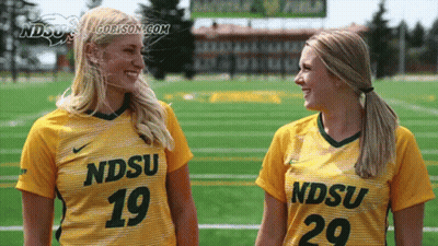 Two Female Athletes Wearing Yellow Jerseys With Ndsu On Them GIF