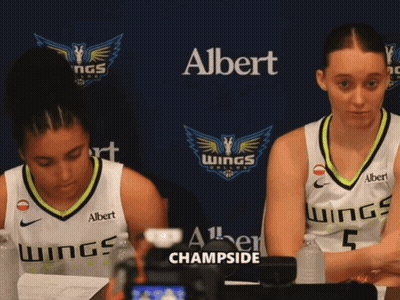 Two Female Basketball Players Are Sitting In Front Of A Banner That Says Albert Champside GIF