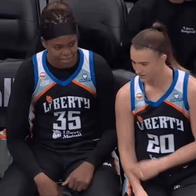 Two Female Basketball Players In Liberty Jerseys Sitting On Bench GIF