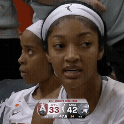 Two Female Basketball Players In Stands With Scoreboard 33-42 GIF