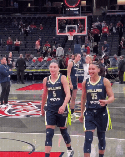 Two Female Basketball Players Wearing Dallas Jerseys Are Walking On The Court GIF