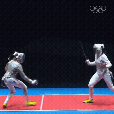 Two Female Fencers Are Fighting Each Other On A Court . GIF