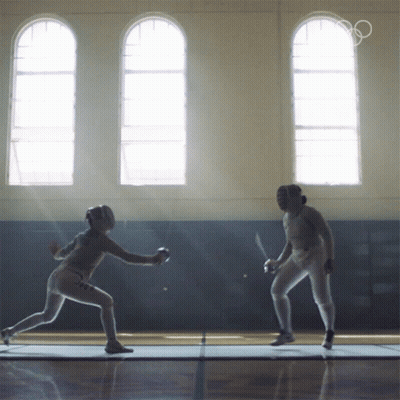 Two Female Fencers Are Fighting In A Gym With The Olympics Logo In The Background GIF