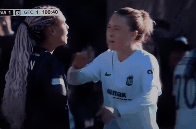 Two Female Soccer Players Hugging In Front Of Scoreboard Saying GFC 1 GIF