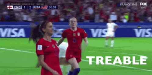 Two Female Soccer Players On A Field With The Word Treable In The Corner GIF