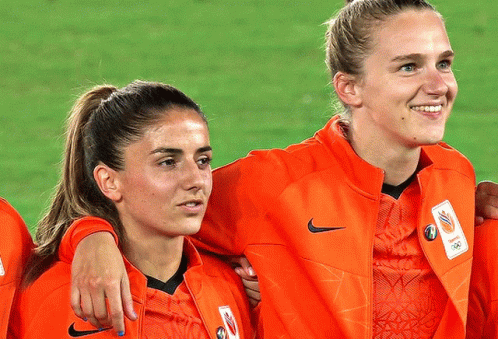 Two Female Soccer Players Wearing Orange Nike Jackets GIF
