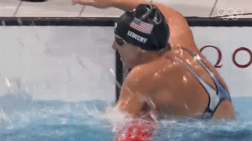 Two Female Swimmers Are Swimming In A Pool And One Of Them Is Wearing A Lefferts Swim Cap GIF