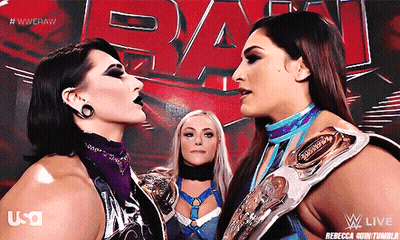 Two Female Wrestlers Face Each Other In Front Of A Wwe Logo GIF