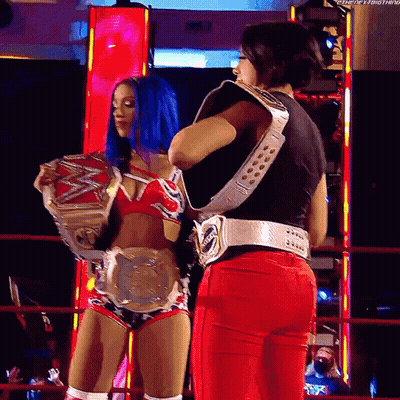Two Female Wrestlers Holding Belts In Ring GIF