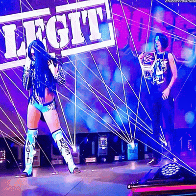 Two Female Wrestlers On Stage With Legit Sign GIF
