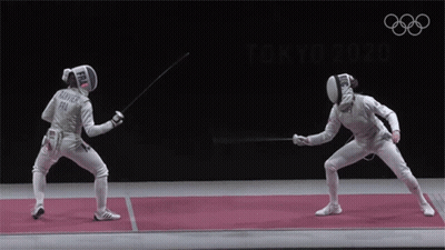 Two Fencers Are Fighting On A Mat With The Olympic Rings In The Background GIF