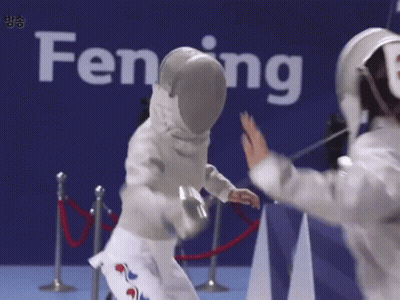 Two Fencers Are Giving Each Other High Fives In Front Of A Sign That Says Fencing GIF