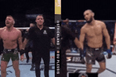 Two Fighters Are Standing In Front Of A Sign That Says Ostrichland Du Plessis GIF