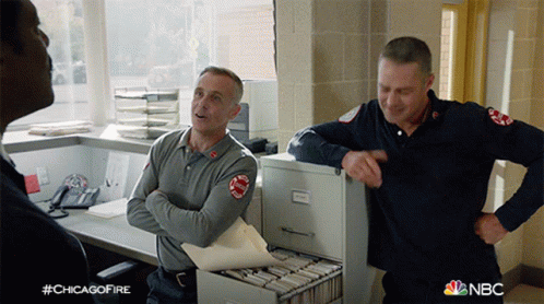 Two Firefighters In Front Of Filing Cabinet With NBC GIF