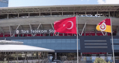 Two Flags Flying In Front Of Turk Telekom Building GIF