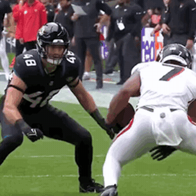 Two Football Players Are Playing A Game On A Field And One Has The Number 7 On His Jersey GIF