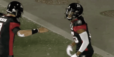 Two Football Players Are Shaking Hands On The Field . One Of The Players Is Wearing A Number 7 Jersey . GIF