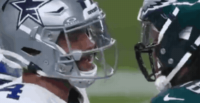 Two Football Players Are Standing Next To Each Other On A Field And Talking To Each Other . GIF