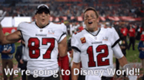 Two Football Players Are Standing Next To Each Other On A Field With The Words `` We 'Re Going To Disney World '' . GIF