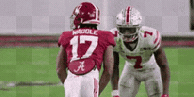 Two Football Players Are Standing Next To Each Other On The Field . One Of The Players Has The Number 17 On His Jersey . GIF