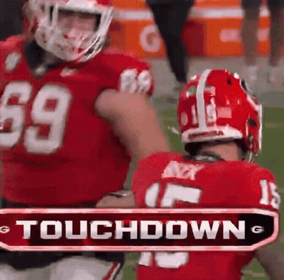 Two Football Players Are Standing Next To Each Other With A Touchdown Sign In The Background GIF