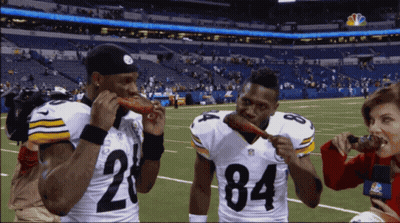Two Football Players Eating Meat GIF