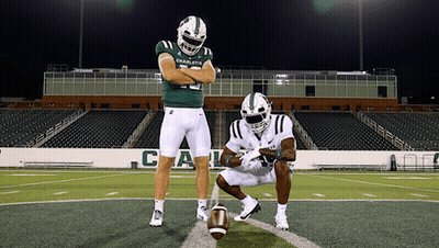 Two Football Players From The Charlotte Team Are Posing For A Picture GIF