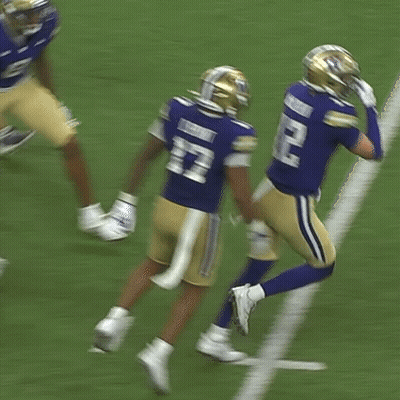 Two Football Players In Blue Uniforms With Letter W GIF