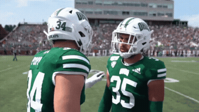 Two Football Players In Green And White Uniforms Numbers 34 And 35 GIF