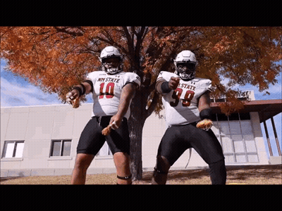 Two Football Players In My State Jerseys Dancing In Front Of Tree GIF