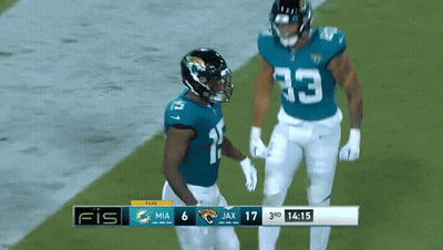 Two Football Players On Field With Scoreboard Saying Fis GIF