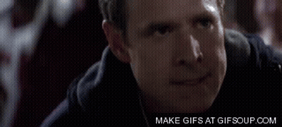 Two Football Players Wearing Helmets Are Standing Next To Each Other GIF