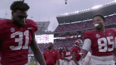 Two Football Players Wearing Red Jerseys With 31 And 95 On Them GIF