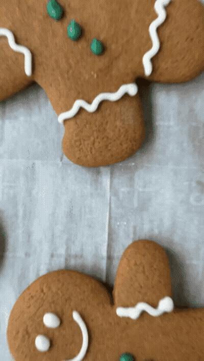 Two Gingerbread Men With Green Sprinkles On Them GIF