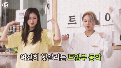 Two Girls Are Dancing In Front Of A Sign That Says ' Twice ' On It GIF