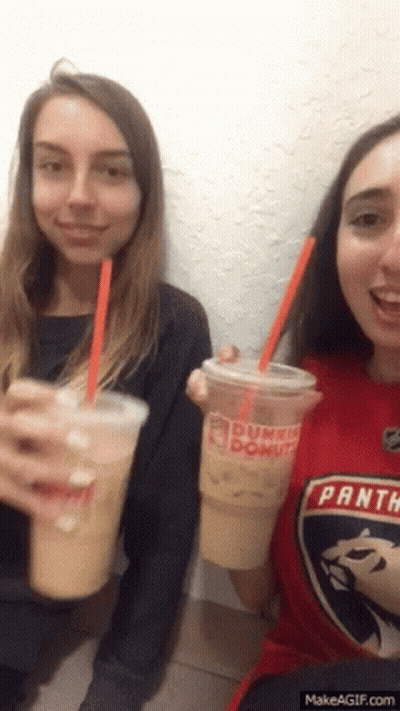 Two Girls Are Drinking Dunkin Donuts Drinks And One Has A Panthers Shirt On GIF