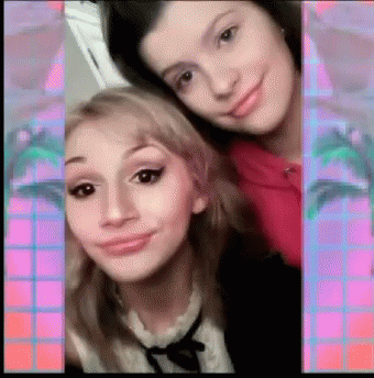 Two Girls Are Posing For A Picture And One Of Them Is Wearing A Pink Shirt GIF