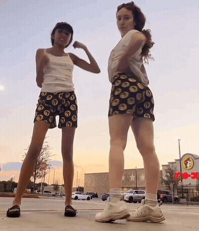 Two Girls Are Posing For A Picture In Front Of A Wendy 'S Restaurant GIF