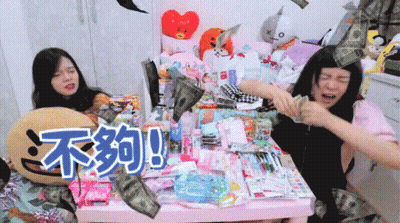 Two Girls Are Sitting At A Table With Chinese Writing On The Table GIF