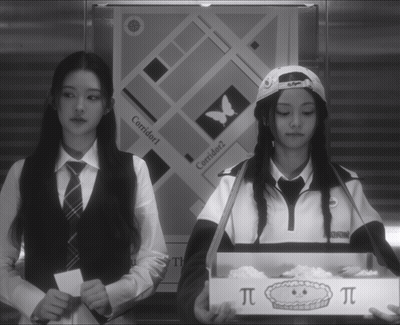 Two Girls Are Standing In Front Of A Sign That Says Corridor 1 GIF