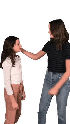 Two Girls Are Standing Next To Each Other And One Is Touching Another 'S Face Sticker