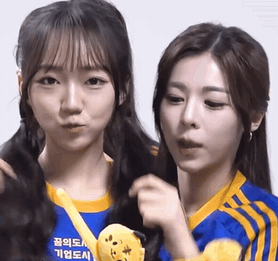 Two Girls Are Standing Next To Each Other With One Wearing A Blue Shirt That Says ' Seoul ' On It GIF