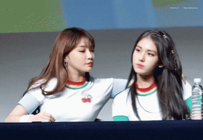 Two Girls Are Standing Next To Each Other With One Wearing A Rainbow Shirt With Cherries On It GIF