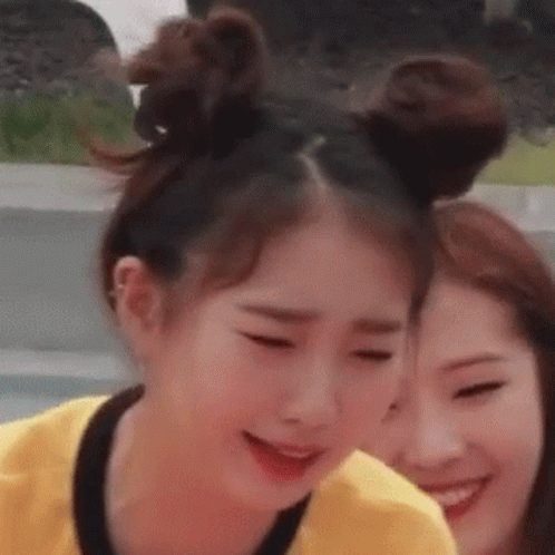 Two Girls Are Standing Next To Each Other With Their Hair In Buns And Smiling . GIF