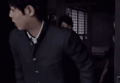 Two Girls In School Uniforms Are Standing In A Dark Room . GIF