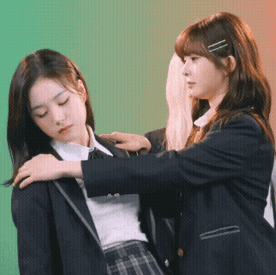Two Girls In School Uniforms Are Standing Next To Each Other And One Is Putting Her Hand On The Other 'S Shoulder GIF