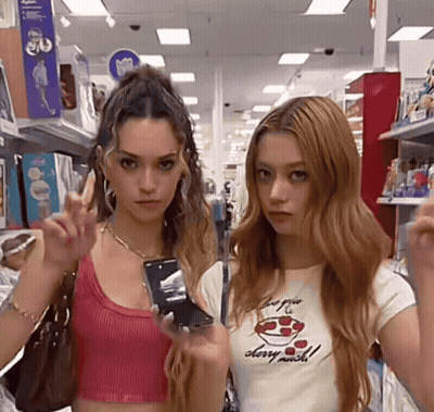 Two Girls In Store One Wearing Cherry Much Shirt GIF