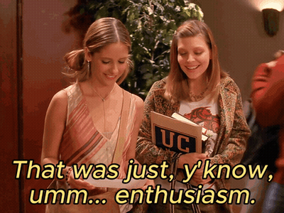 Two Girls Looking at Book With UC on Cover