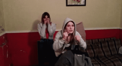 Two Girls On Couch One Wearing Hoodie GIF